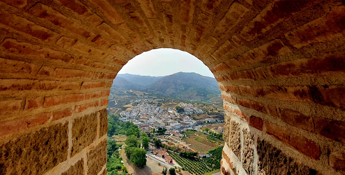 Vista de Álora enmarcada por un arco de piedra